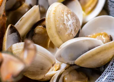 clams and other seafood are being cooked in a pan