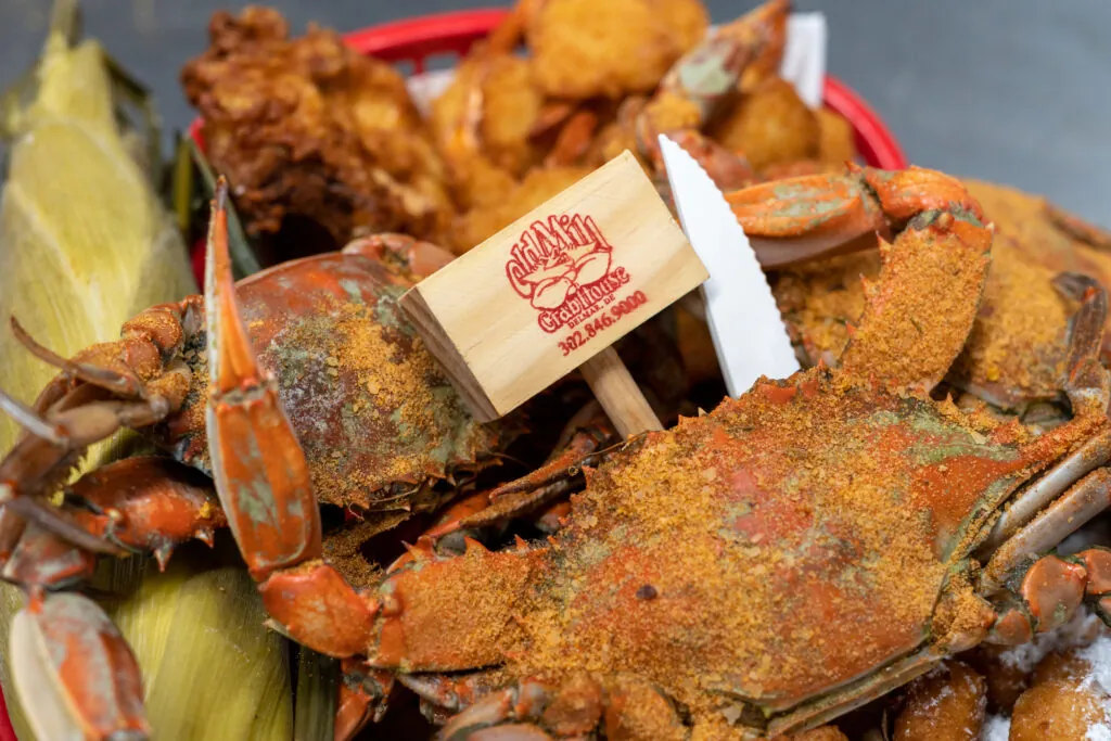 a basket filled with cooked crabs and other foods