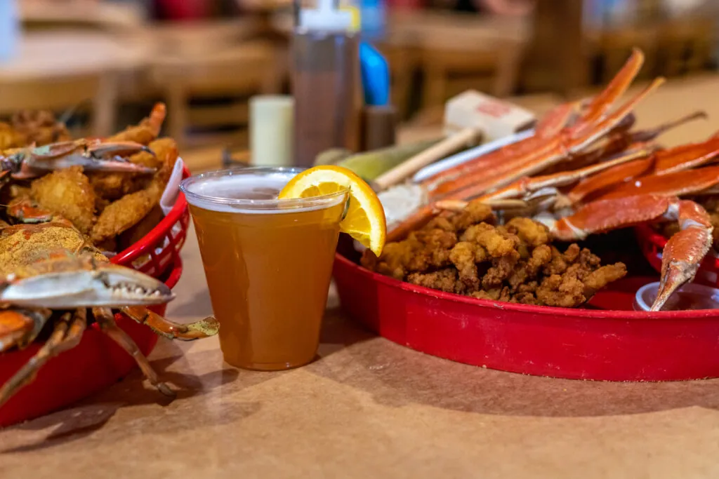 there is a bowl of crab legs and a cup of beer