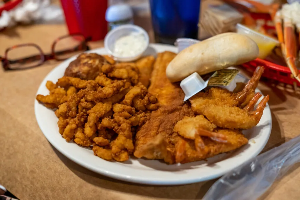 a white plate topped with fried food next to glasses